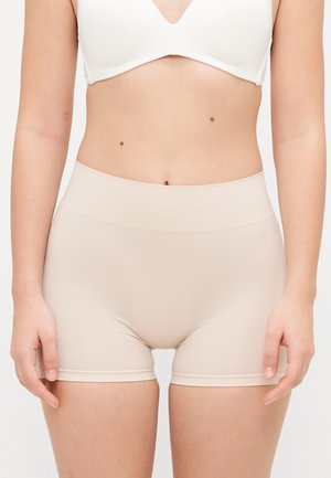 Beige seamless shorts with a high waistband. Smooth texture and fitted design, featuring a subtle trim at the leg openings.