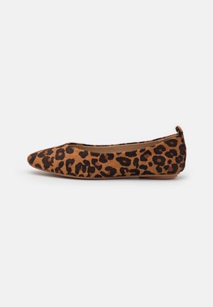 Brun flad sko med sort leopardmønster og en lille løkke ved hælen, vist fra siden på en hvid baggrund.