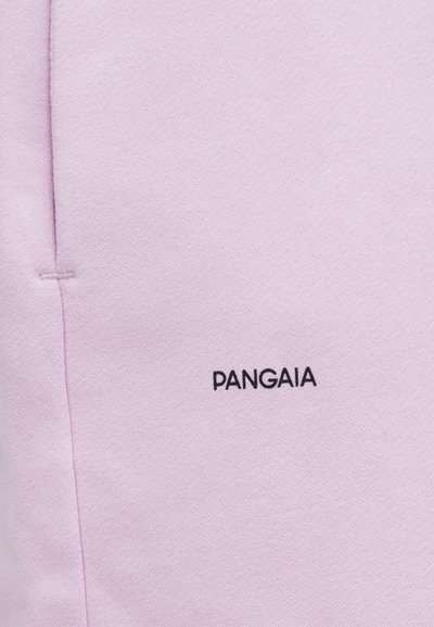 Lyse lilla stof med sort "PANGAIA" tekstlogo broderet nær en lodret søm.