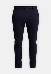 Marineblauwe skinny-fit broek gemaakt van een rekbare stof, met een ritssluiting, knoopsluiting en voorzakken. Soepele textuur en strakke lijnen.