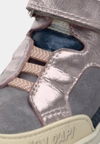 Fioletowe zamszowe buty sportowe z błyszczącymi metalicznymi akcentami, perforowanymi detalami i rzepem, z teksturowaną gumową podeszwą.