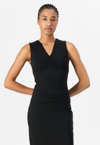 Čierny top bez rukávov s výstrihom do V a zhromaždením v oblasti hrudníka, vyrobený z hladkého, elastického materiálu. Fitted dizajn.