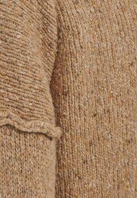 Maglione lavorato a maglia in un caldo beige con una finitura testurizzata, caratterizzato da sfumature dorate e crema. Include un orlo ondulato e filato morbido e spesso.