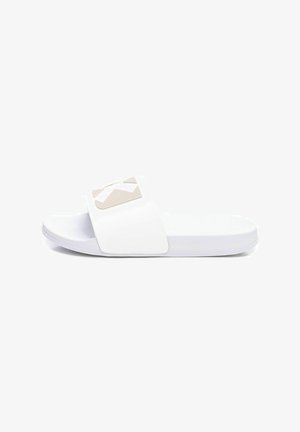 Sandalia deslizante blanca con una correa ancha que presenta un logotipo geométrico beige. Textura suave, suela plana y diseño minimalista.