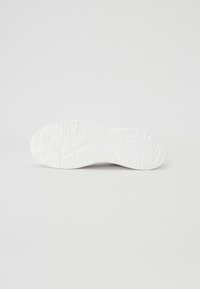 Fehér sneakerszól, amelyen texturált tapadásmintázat található, markáns bordákkal és ívekkel, a tapadás és tartósság érdekében tervezve.