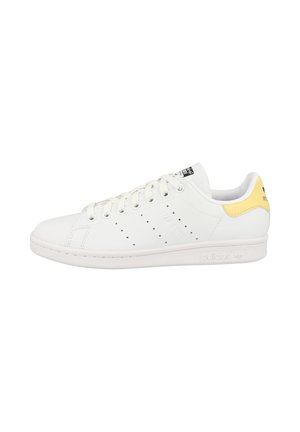 Weiße Ledersneaker mit gelbem Akzent an der Ferse. Verfügt über eine Gummisohle, perforierte Details an den Seiten und flache Schnürsenkel.