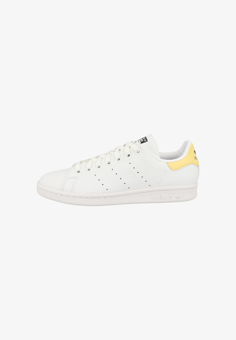Weiße Ledersneaker mit gelbem Akzent an der Ferse. Verfügt über eine Gummisohle, perforierte Details an den Seiten und flache Schnürsenkel.