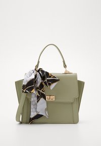 Bolso de mano verde de imitación cuero con un diseño estructurado, herrajes dorados y una bufanda decorativa con un patrón atada en el asa.