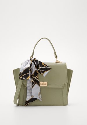 Bolso de mano verde de imitación cuero con un diseño estructurado, herrajes dorados y una bufanda decorativa con un patrón atada en el asa.