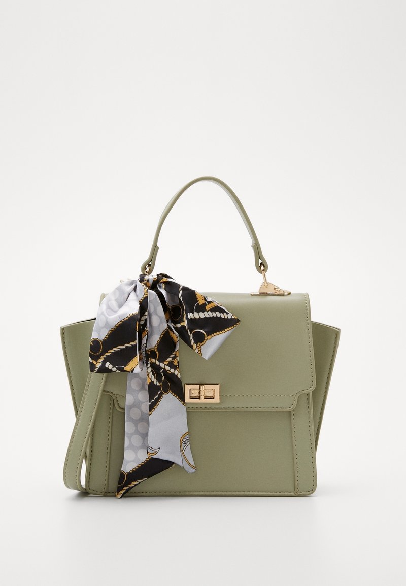 Bolso de mano verde de imitación cuero con un diseño estructurado, herrajes dorados y una bufanda decorativa con un patrón atada en el asa.