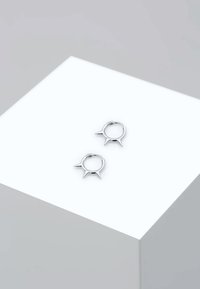 Sølv hoop øreringe med spidse accenter. Hver ørering har en glat, cirkulær form med tre fremspringende pigge.