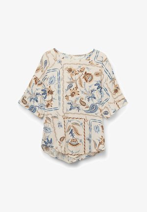 Vloeiende blouse in crème met een blauw en bruin bloemenpatroon. Heeft een ronde halslijn en driekwart mouwen. Zacht, lichtgewicht stof.