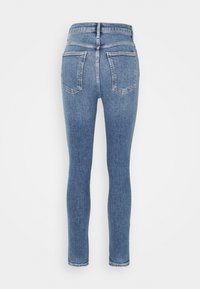 Jeans ajustados de tiro alto en denim azul medio. Cuenta con dos bolsillos traseros y un acabado limpio con un leve estiramiento para mayor comodidad.