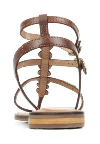 Sandale en cuir marron avec plusieurs sangles, une texture lisse et une semelle plate présentant un discret design superposé. Détail de boucle ajustable inclus.