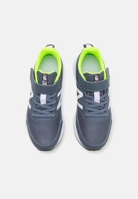 Šedé sportovní boty s síťovinou, neonově zeleným vnitřkem, bílými akcenty, zapínáním na suchý zip a tkaničkami pro bezpečné uchycení.