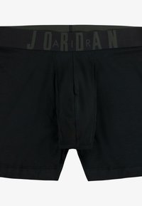 Boxers noirs avec une ceinture élastique texturée arborant le mot "JORDAN" en gris foncé contrastant. Tissu lisse, design ajusté.