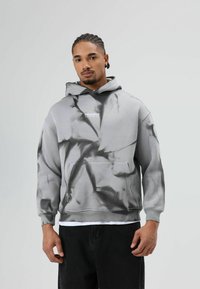 Grijze hoodie met een tie-dye patroon, voorzien van een voorvak, verstelbare capuchon en het "PRESENTED" logo op de borst in witte tekst.