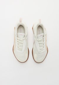 Scarpe da ginnastica bianche con superiore in rete, design con lacci e suola in gomma testurizzata. Accenti laterali in evidenza in beige chiaro e branding rosa.
