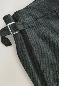 Tamno sivi teksturirani hlače s bočnim detaljem kopče, s čistim pojasom i suptilnim tkanim uzorkom.