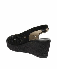 Sandale compensée noire avec un dessus perforé et un dos ouvert. Conçue en matériau doux semblable au daim avec une semelle de plateforme texturée.