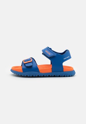 Sandalias azules y naranjas fabricadas en material sintético, con dos correas ajustables y una suela de goma texturizada para mayor agarre.