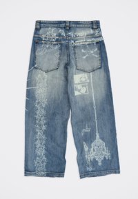 Μπλε τζιν με λευκά τυπωμένα σχέδια που περιλαμβάνουν λουλουδένια μοτίβα, μουσικές νότες, ένα κρανίο με οστά και έναν κρεμαστό πολυέλαιο.