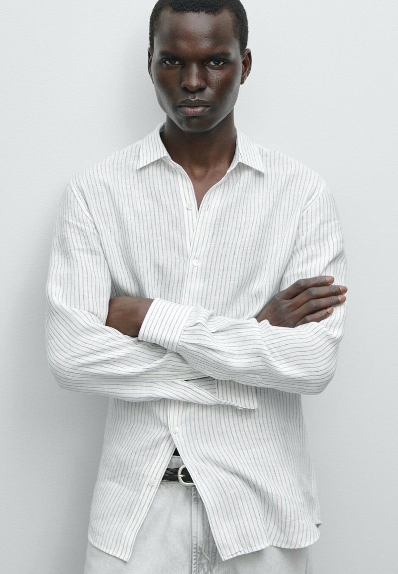 Camicia a righe in tessuto leggero, con colletto, maniche lunghe e vestibilità dritta, con sottili linee blu su sfondo bianco.