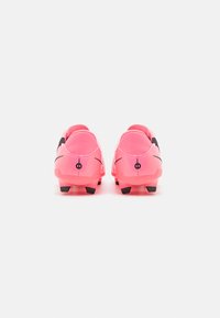 Pink soccer cleats with black accents, smooth synthetic material, low profile, and five black studs on the outsole for traction.