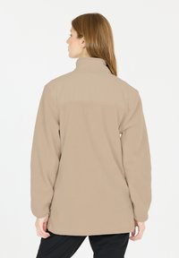 Beige fleecejakke med høj krave, tekstureret stof og en afslappet pasform. Bagsiden har et solidt overdelspanel og lange ærmer.