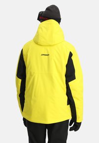 Gelbe wasserdichte Jacke mit schwarzen Akzenten, Kapuze und Logo auf dem Rücken. Hat eine glatte Textur und einen lockeren Schnitt, geeignet für den Einsatz im Freien.