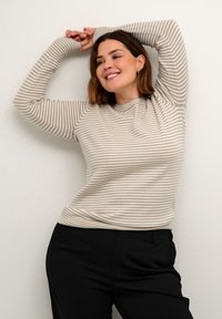 Light gray ribbed sweater with horizontal beige stripes, round neck, and long sleeves, paired with black tailored pants.