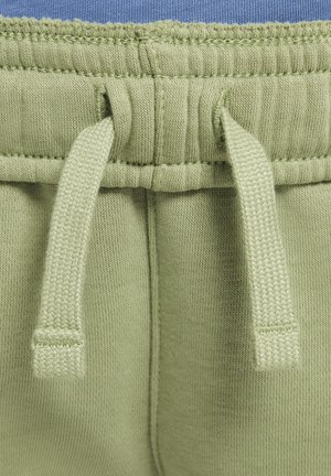 Pantalons de jogger vert clair avec une taille élastique à cordons, une texture douce et des détails côtelés le long des bords.