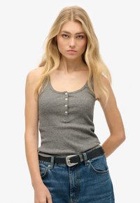 Grå ribbet tanktop med en rund halsudskæring og fem knapper. Sættes sammen med højtaljede blå denim jeans og et sort bælte med en sølvspænde.