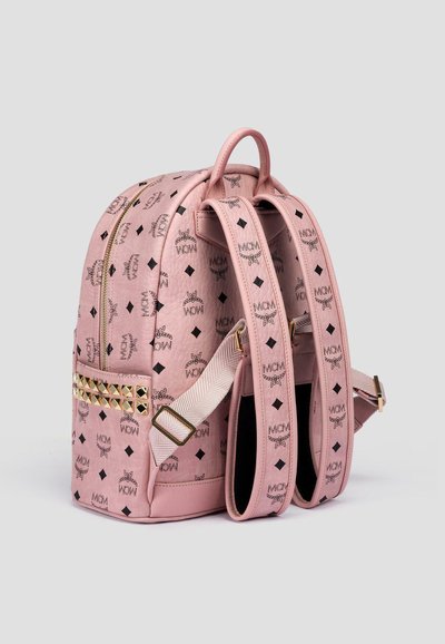 Zaino in pelle rosa con superficie testurizzata, motivo logo riconoscibile, dettagli in oro a borchie, spallacci regolabili doppi e manico superiore.