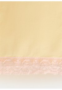Tissu jaune clair avec une large bordure en dentelle rose pâle présentant un motif floral et géométrique le long du bord.