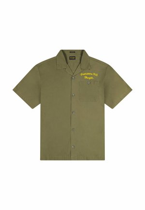 Koszula z krótkim rękawem w kolorze oliwkowej zieleni, z zapięciem na guziki, naszywaną kieszenią i żółtym haftowanym napisem po lewej stronie na wysokości klatki piersiowej.