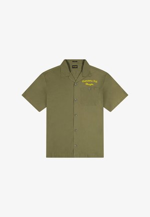 Chemise manches courtes vert olive avec devant à boutons, poche plaquée et texte brodé jaune sur la poitrine gauche.