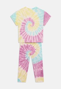 Tvådelat hemmaklädnadset med tie-dye mönster i pastellfärger: gult, rosa och blått. Kortärmad topp och leggings ingår.