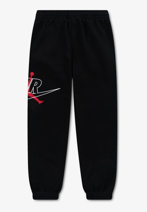 Pantalon de survêtement noir avec taille et chevilles élastiques, muni d'un logo Air Jordan Jumpman rouge et blanc sur la cuisse gauche.