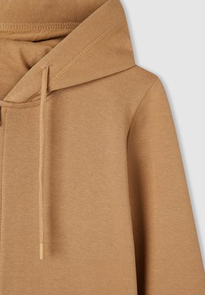 Beżowa bluza z kapturem, z miękkiej tkaniny, o prostym fasonie z widocznymi detalami szwów.