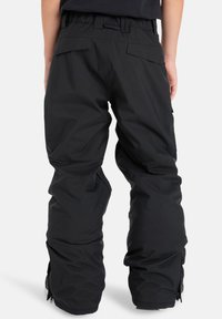 Zwarte sneeuwbroeken met een relaxte fit, elastische tailleband, twee achterzakken en ritssluitingen bij de enkels voor eenvoudige layering. Duurzaam materiaal.