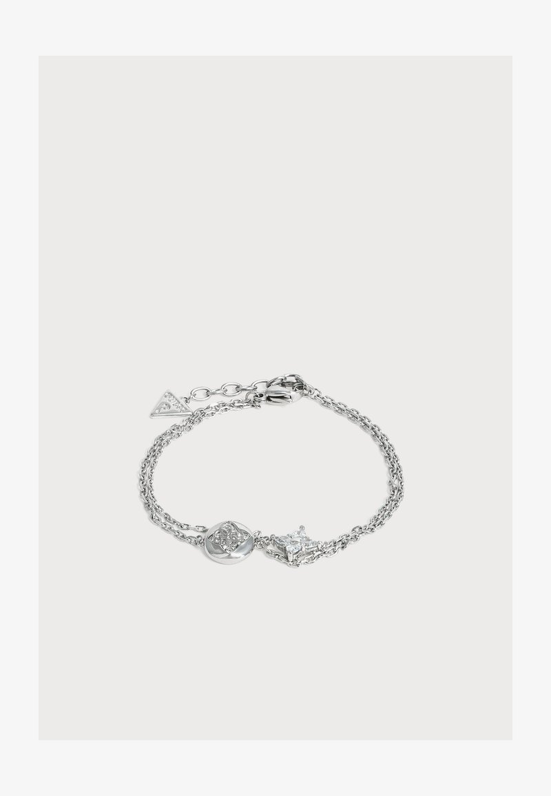Bracelet chaîne en argent avec deux pendentifs décoratifs, un rond avec de petits cristaux, un en forme d’étoile avec une pierre claire.