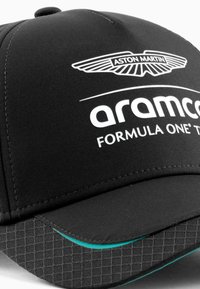Gorra negra con visera curvada, que presenta el logo de Aston Martin y el texto "aramco" en blanco. Subvisera texturizada negra con acento en verde azulado.