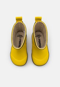 Bottes en caoutchouc jaunes pour la cheville avec une texture lisse, semelles noires et un intérieur à motifs. Comprend une languette pour un enfilage facile. Taille 20.
