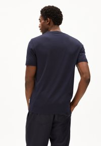 Marineblauw katoenen T-shirt met korte mouwen en een ronde halslijn, met een zachte textuur en een subtiele logotag aan de zijkant.