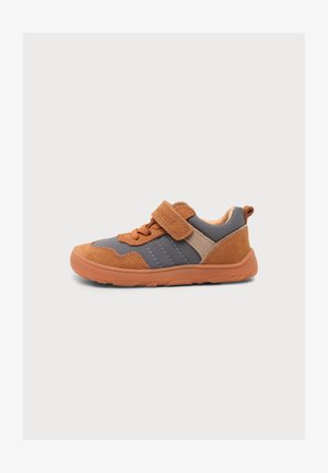 Παιδικό αθλητικό παπούτσι χαμηλό σε καφέ και γκρι με κορδόνι και λουράκι βέλκρο, μαλακή σόλα και θηλιά στη φτέρνα για εύκολο φόρεμα.