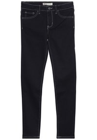 Jeans de denim negro con corte ajustado, costuras blancas en contraste, diseño de cinco bolsillos y cierre de botón en la cintura.