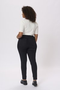 Jeans neri a vita alta con una vestibilità slim, dotati di tasche posteriori e una maglietta bianca a maniche corte con texture. Tessuto liscio, design casual.