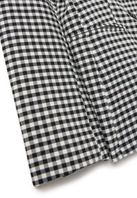 Tela de cuadro vichy en blanco y negro, con pequeños cuadrados dispuestos en una cuadrícula, con una textura suave y bordes limpios.
