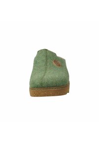 Zielony filcowy but wsuwany z tanowym korkowym spodem, z okrągłym logo naszywką i kontrastowym szyciem wzdłuż krawędzi podeszwy.